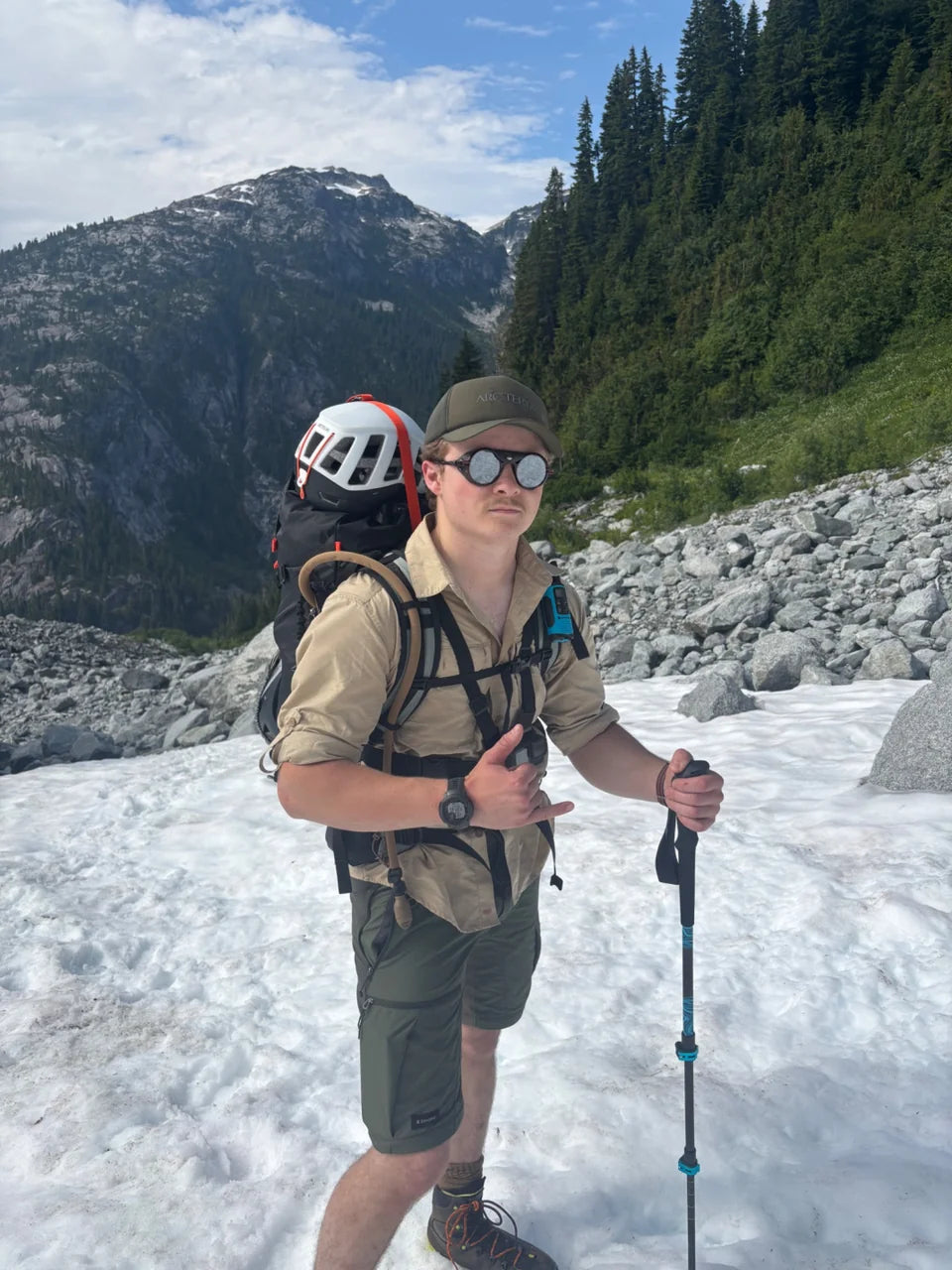 Oscar standing on snow with trekking poles and climbing equipment.